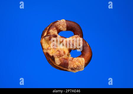 Freshly home backed Pretzel. Close up studio shot, isolated on blue. Stock Photo