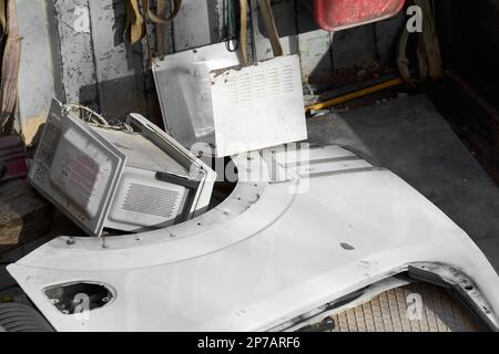 Picture of scrap inside a truck for recycling, scrap from a microwave oven and a vehicle door ready to be taken to the recycling plant. Stock Photo