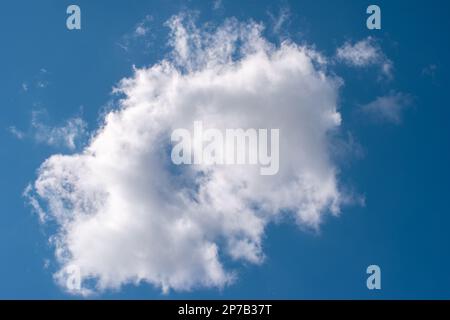 Puffy white cloud on blue summer sky. Stock Photo