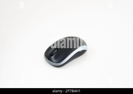 Small black wireless computer mouse isolated on white background. Close up studio shot, no people. Stock Photo