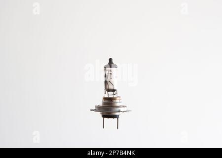 Burned H7 12V 55W halogen car light bulb. Close up studio shot, isolated on white, no people. Stock Photo