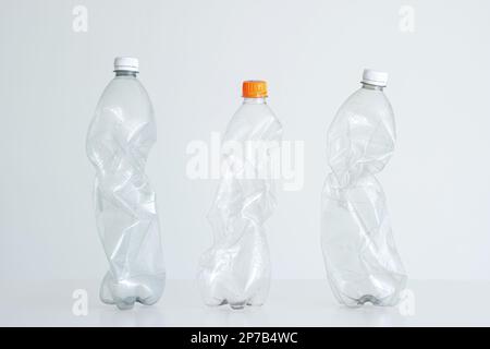 3 large clear squeezed plastic water bottles with close caps. Studio shot, isolated on white, no people. Stock Photo
