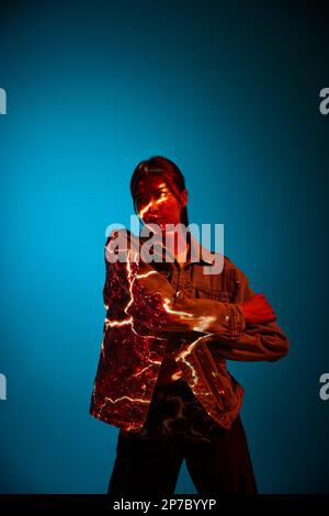 Energy. Futuristic style portrait of young woman with digital neon filter lights on clothes over dark blue background. Stock Photo