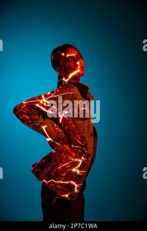 Energy. Futuristic style portrait of young woman with digital neon filter lights on clothes over dark blue background. Stock Photo
