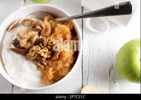 Low carb protein breakfast with islandic skyr, grated apples and nuts on white table background. Stock Photo