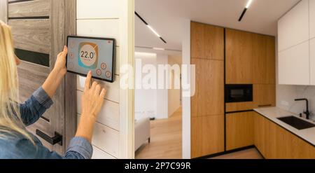 Woman using smart wall home control system Stock Photo