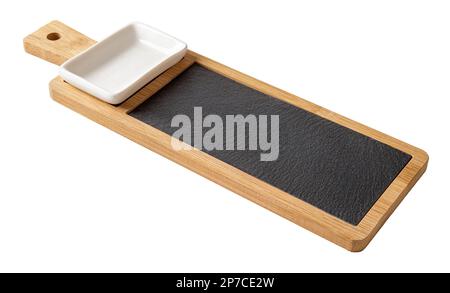 Bamboo sushi roll serving board with handle cutout. Lond wooden board with black slate tray and porcelain soy sauce dish isolated on white background. Stock Photo
