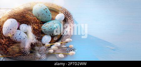 Easter holiday decoration on blue wooden background; sunny Easter morning Stock Photo