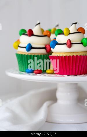 Cakestand with Christmas cupcakes decorated with colorful Christmas lights Stock Photo