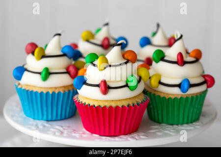 Christmas cupcakes decorated with strings of colorful candy Christmas lights Stock Photo