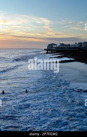The beach at Worthing at sunset with breaking waves on the beach, West Sussex England UK Stock Photo
