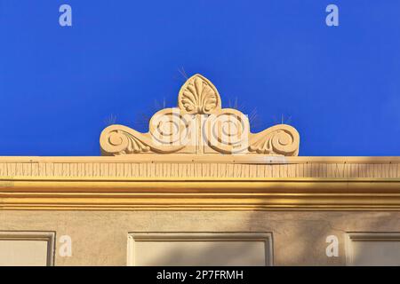 530 Baroque roof finial with acroterion atop an orange-yellow painted Art-Deco building on The Corso-Manly suburb. Sydney-Australia. Stock Photo