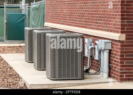 Horizontal shot of three air conditioners outside of a sports complex. Stock Photo