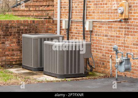 Horizontal shot of two commercial air conditioners outside of a multi-office building Stock Photo