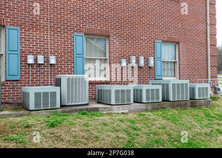 Horizontal shot of a line of air conditioners outside of a commercial building. Stock Photo