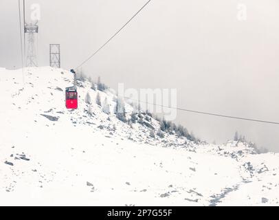 Winter landscape with an old, red cable car on Transfagarasan, Romania Stock Photo