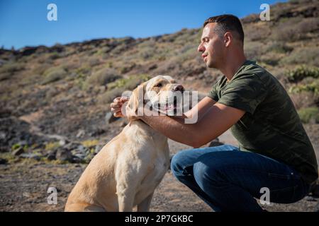 A dog trainer puts the collar on a golden retriever, photo with copy space. Stock Photo
