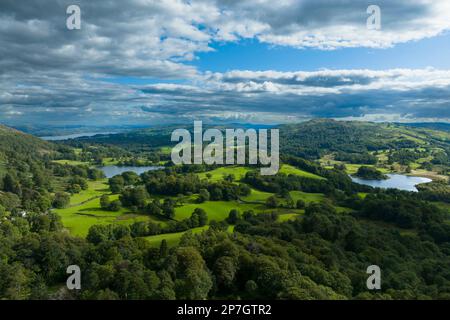 England, Cumbria, Lake District National Park. Aerial view of Elterwater, Loughrigg Tarn and Lake Windermere looking south towards the southern lake d Stock Photo