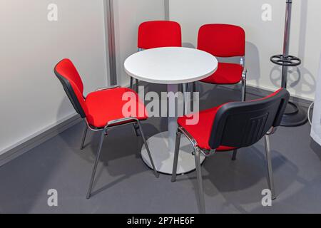 Round White Table With Four Red Chairs Office Booth Stock Photo