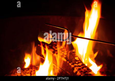 Marshmallow roasts over open campfire Stock Photo