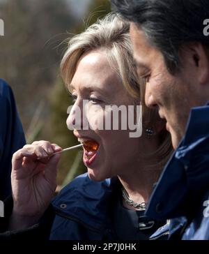 U.S. Secretary of State Hillary Clinton tries maple taffy following a family photo at the G-8 Foreign Ministers meeting in Gatineau, Canada, Tuesday March 30, 2010. At right is Japan's Foreign Minister, Katsuya Okada. (AP Photo/The Canadian Press, Adrian Wyld)