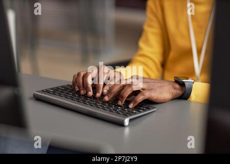 Close up of male hands typing at keyboard while using computer in high tech office, copy space Stock Photo