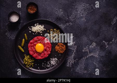 Fresh beef tartar with tasty vegetables, top view. Stock Photo