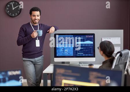 Portrait of smiling man chatting with colleague at coffee break in IT company office, copy space Stock Photo