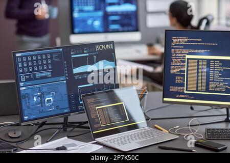 Background image of multiple computer screens with data and code on desk in IT development office, copy space Stock Photo
