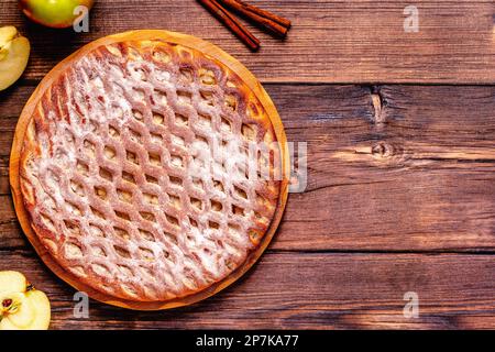 Homemade apple pie with cinnamon on a wooden background. Top view. Stock Photo