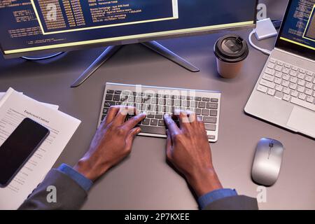 Top view of male hands typing at computer keyboard at workplace in high tech IT office Stock Photo