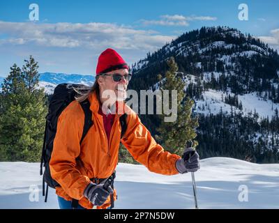 WA23242-00...WASHINGTON - Cross-country skier enjoying the afternoon sunshine and views from the Cassal Hut Trail in the Rendezvous area. Stock Photo