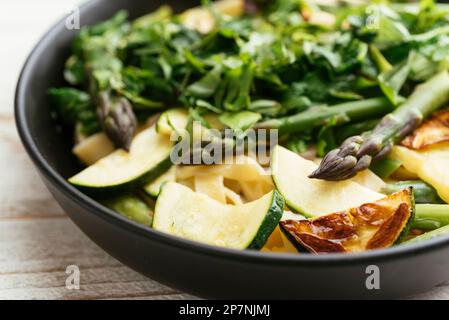 Bowl with home made tagliatelle with green asparagus, zucchini and spinach. Stock Photo