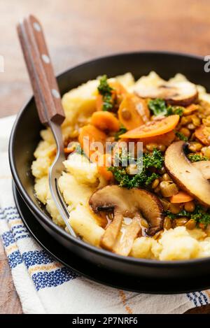 Lentil Stew with kale, carrots and mushrooms on mashed potatoes. Stock Photo