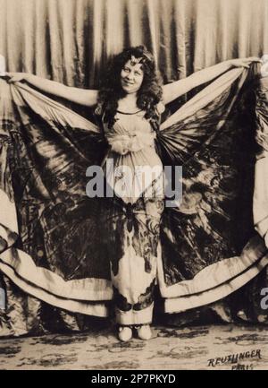 1900 c, FRANCE : The celebrated american dancer of parisian Belle Epoque LOIE FULLER ( 1862 – 1928) , a pioneer of both modern dance and theatrical lighting techniques, when was a dancer at Les Folies Bergere in Paris in the butterly dance . Photo by Reutlinger , Paris . - BALLERINA - DANCER - BALLET - BALLETTO - DANZA - DANCE  - musa - farfalla  ----  Archivio GBB Stock Photo