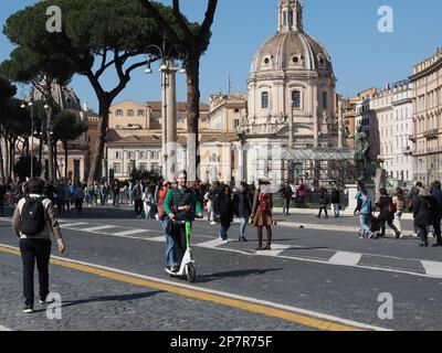 Young couple using a rental electric scooter on Via Dei Fori Imperiali in Rome, Italy Stock Photo