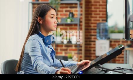 Female graphic designer editing photos with tablet and stylus, using retouching software for pictures post production. Young editor working on multimedia content with skills. Close up. Stock Photo