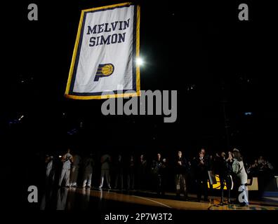 Members of the Simon family lift a banner in honor of the late Indiana  Pacers co-owner Mel Simon before an NBA basketball game in Indianapolis,  Friday, Nov. 6, 2009. The banner bears