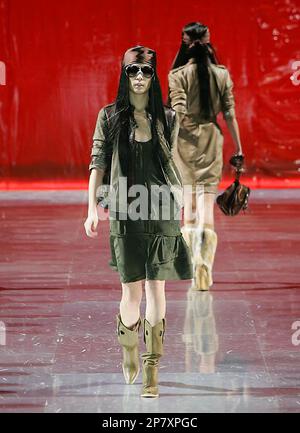 Two models walk the runway in shimmering stretch scoop neck tops with  floral patterned silk Chinese pants during the presentation of Giorgio  Armani's Spring/Summer 2005 collection, Tuesday, Oct. 26, 2004, at Pier