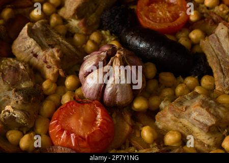 Image from above of a clay pot with baked rice cooked in a homemade way with traditional ingredients such as rice, tomato, potatoes, chickpeas, etc Stock Photo