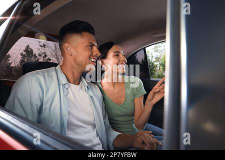 Happy couple on backseat of modern taxi Stock Photo