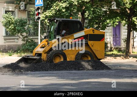 Modern skid loader on city street. Road repair service Stock Photo - Alamy