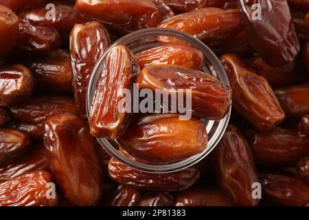 Tasty sweet dried dates and glass bowl, top view Stock Photo