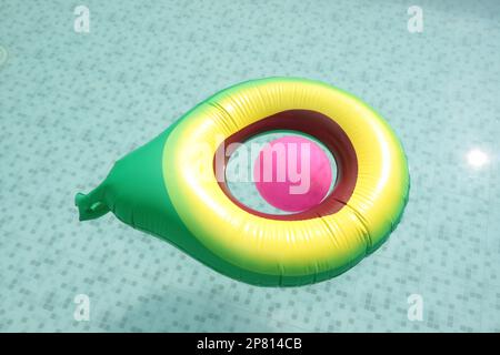 yellow green pool float, floating in the refreshing blue swimming pool Stock Photo