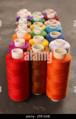 Set of color sewing threads on grey table Stock Photo