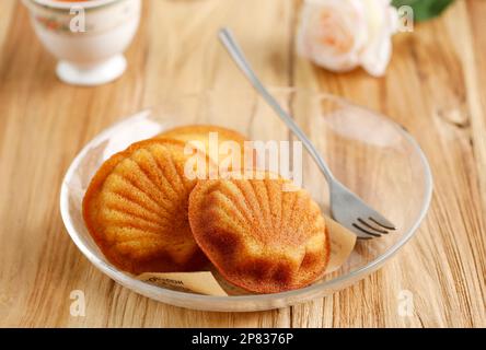 French Madeleine Cookies Cake, Buttery and Delicate, served with cup of Tea, on Wooden Background Stock Photo