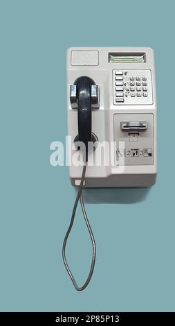 Old public card telephone, mounted on a blue wall Stock Photo