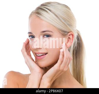 Nothing quite like the feeling of smooth, soft skin. Studio shot of a beautiful blonde touching her face against a white background. Stock Photo