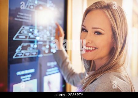Travel made easy. a young woman using an interactive hotel map. Stock Photo