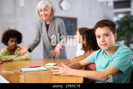 teacher explains to children new information on subject Stock Photo